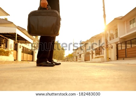 businessman with bag in hand standing on the road in morning