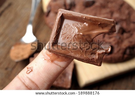 closeup chocolate melting on finger