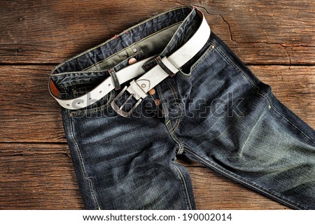 closeup detail of vintage jeans on old wooden desk