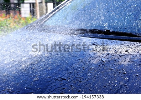 closeup water drop on black car during wahing the car