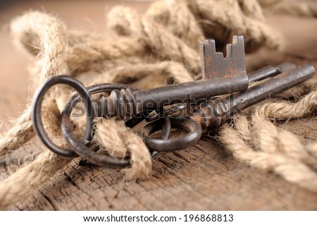 bunch of vintage keys with rope on old wooden plank