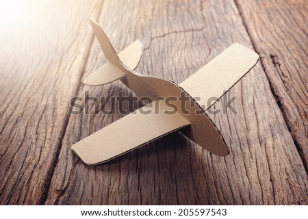 cardboard plane on wooden desk with filtered