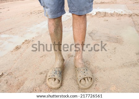man wearing dirty sandals after mired in the mud
