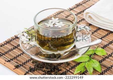 closeup dried green tea leaf with a cup of green tea