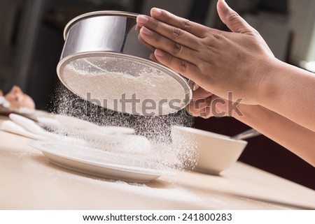 closeup cook\'s hand powdering flour
