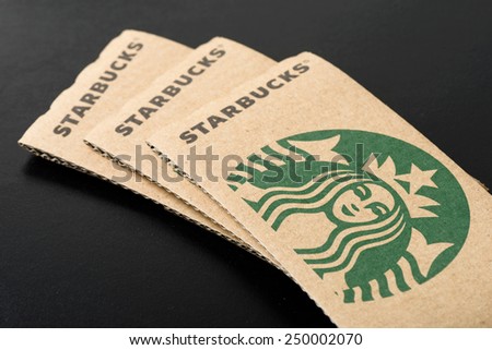 BANGKOK, THAILAND - FEBRUARY 04, 2015: Starbucks coffee cup sleeve on black board. Starbucks is the world\'s largest coffee house with over 20,000 stores in 61 countries.