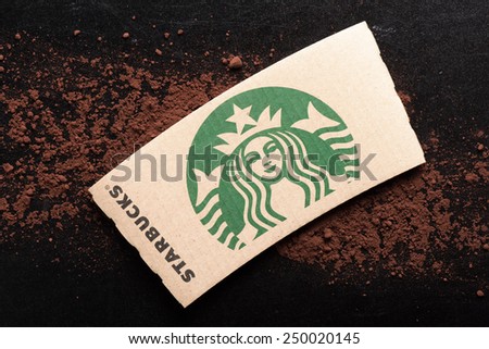 BANGKOK, THAILAND - FEBRUARY 04, 2015: Starbucks coffee cup sleeve and cocoa powder on black board. Starbucks is the world\'s largest coffee house with over 20,000 stores in 61 countries.
