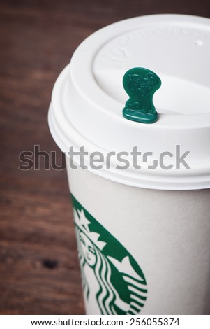 BANGKOK, THAILAND - FEBRUARY 26, 2015: White paper cup with Starbucks logo. Starbucks is the world\'s largest coffee house with over 20,000 stores in 61 countries.