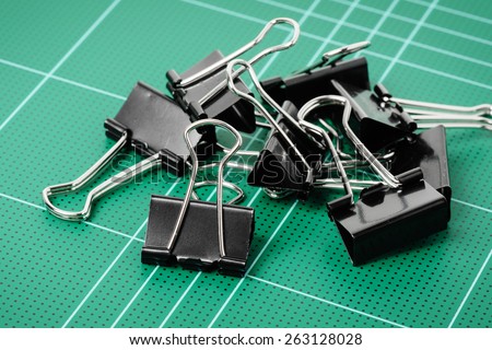 black binder clips isolated on cutting mat