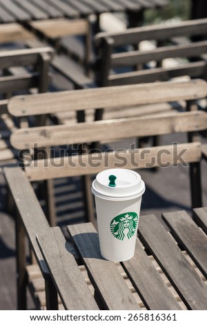 BANGKOK, THAILAND - FEBRUARY 26, 2015: White paper cup with Starbucks logo. Starbucks is the world\'s largest coffee house with over 20,000 stores in 61 countries.