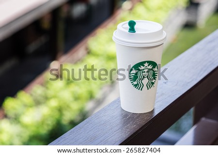 BANGKOK, THAILAND - APRIL 02, 2015: White paper cup with Starbucks logo. Starbucks is the world\'s largest coffee house with over 20,000 stores in 61 countries.