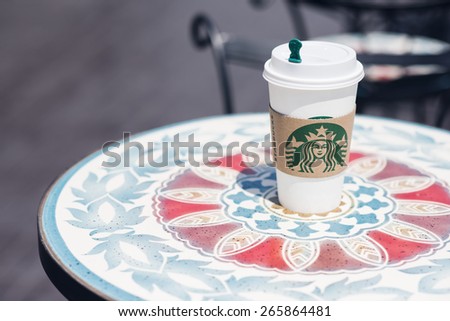 BANGKOK, THAILAND - APRIL 02, 2015: White paper cup with Starbucks logo. Starbucks is the world\'s largest coffee house with over 20,000 stores in 61 countries.