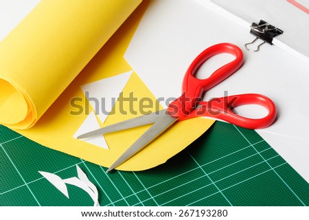 cutting paper with red scissors