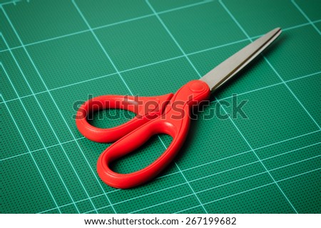 closeup red scissors isolated on cutting mat