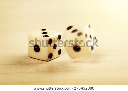 two old plastic dice on the wooden table