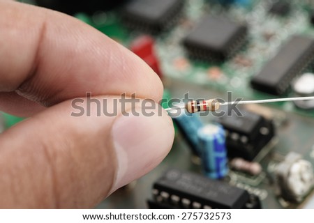 closeup 1K or 1000 Ohms resistor in hand