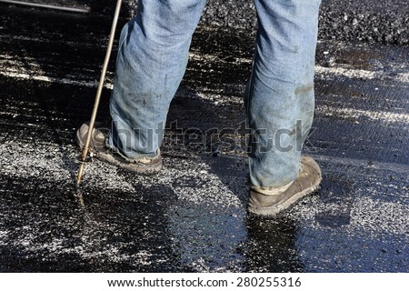 closeup very dirty worker\'s shoes during road construction and repairing works