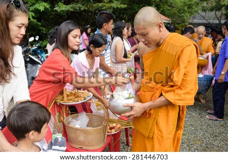 CHONBURI, THAILAND - OCTOBER 09, 2014: Unidentified people offer food to monks in Tak Bat Devo. Tak Bat Devo is the tradition to recall when the Buddha returned from his visit to his mother in Heaven.