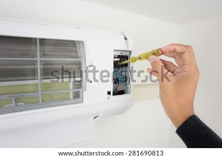 closeup man\'s hand checking air conditioner in the room
