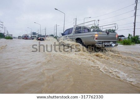 CHONBURI, THAILAND - SEPTEMBER 17, 2015: Many people driving the car through flooded area after the storm VAMCO rain.