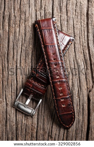 brown leather watch band on wooden table