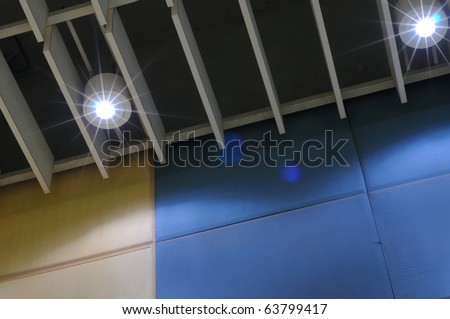 shape of lighting on blue and yellow meeting room backdrop