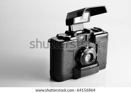 vintage film camera cover open with build-in pop-up flash in black and white