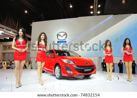 NONTHABURI, THAILAND - MARCH 26: Unidentified female models pose with the new Mazda3 in the 32nd Bangkok International Motor Show on March 26, 2011 in Nonthaburi, Thailand.