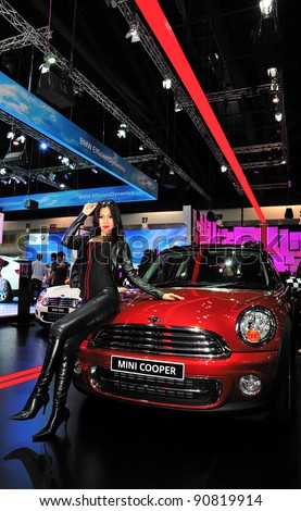 BANGKOK, THAILAND - DECEMBER 4: An unidentified female presenter present Mini Cooper at Mini booth in the Thailand International Motor Expo 2011 at IMPACT on December 4, 2011 in Bangkok, Thailand.