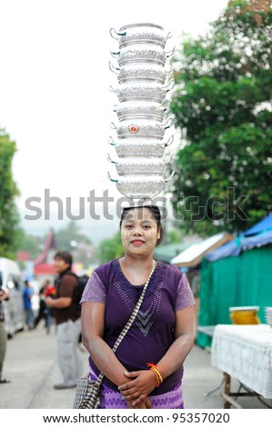 KANCHANABUR, THAILAND - FEBRUARY 12: An unidentified Mon women perform carrying the things on her head on February 12, 2012 in Thailand. Carrying things on the head is traditional culture of Mon.