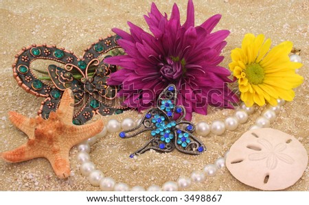 Flowers and Antique Jewelry with Sea Shells on Sand