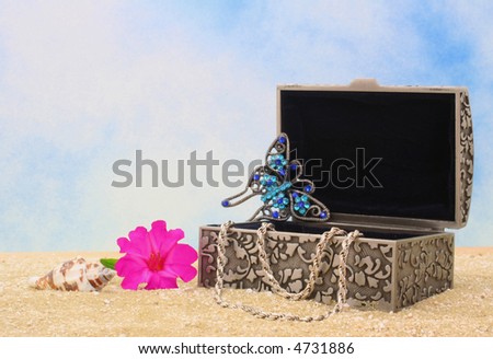 Jewelry Box on Sand With Necklace and Flower