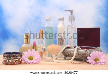 Jewelry Box With Cosmetics, Flowers and Perfume on Blue Textured Background