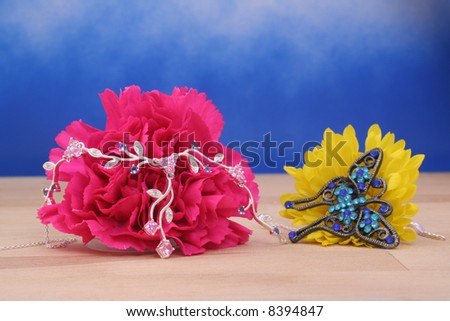 Silver Necklace on Pink Carnation on Blue Background