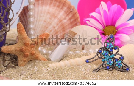 Sea Shells With Flower and Jewelry on Sand With Water Reflection