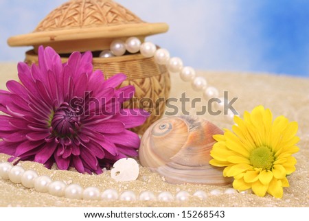 Flowers and Jewelry on Sand With Blue Background
