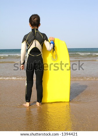 A boy, with its body board, is evaluating the surf