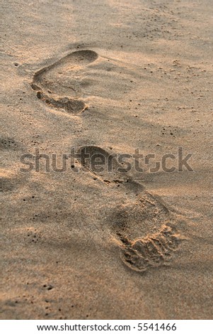 foot prints on the beach sand on sunrise