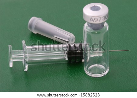 syringe needle and medical stuff on green leather surface