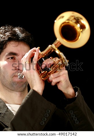 trumpet player on a black background and his golden trumpet