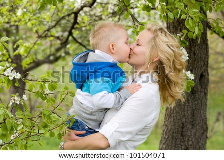 Pretty young mother getting a huge kiss from her baby son.
