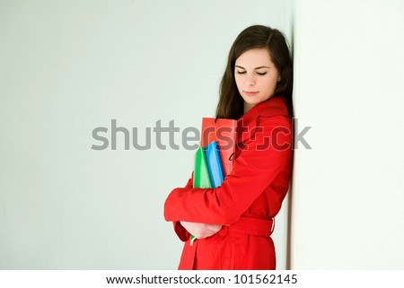 Portrait of a confident friendly young student woman in bright red coat.