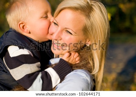 Family love, young boy kissing his happy mom.