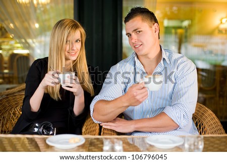 Portrait of a young couple at coffee shop drinking.