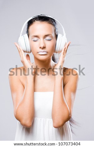 White noise, gorgeous young brunette woman listening to music in headphones.