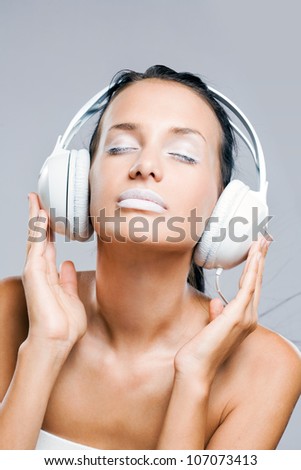 White noise, gorgeous young brunette woman listening to music in headphones.