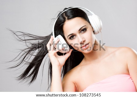 Portrait of a brunette beauty wearing white headphones.