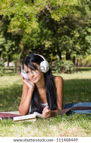 Portrait of a young student girl learning, relaxing in the park.