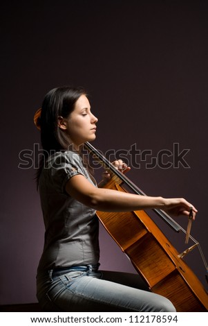 Passionate real artist, young woman playing her classical instrument.