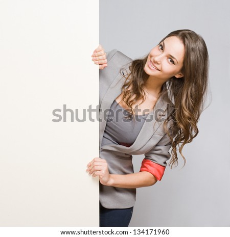 Portrait of gorgeous young businesswoman with large blank banner.